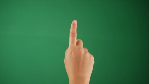 A person rotating the index finger against a green background - hand gestures. Closeup shot of a human hand swapping the finger of the right hand while using a chroma-key device