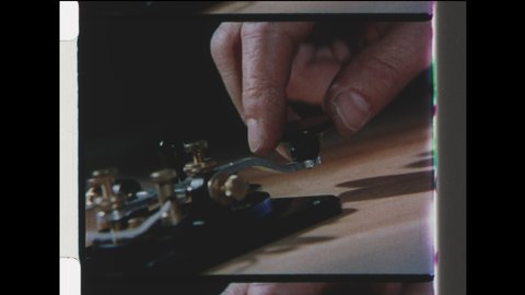 1940s Washington, DC. Close Up of Hand on Telegraph key Transmitting Morse Code. 4K Overscan of Vintage Archival 16mm Film Print
