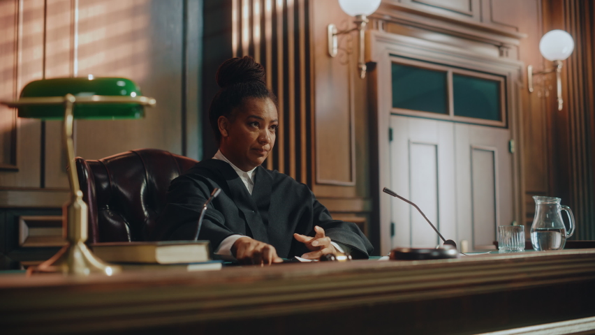 Court of Law Trial in Session: Portrait of Honorable Female Judge Reading Decision, striking Gavel. Presiding Justice Pronouncing Sentence. Not Guilty Verdict Judgment. Cinematic Medium Shot Royalty-Free Stock Footage #1076370818