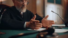 Court of Law and Justice Trial: Honorable Male Judge Discussing Pleaded Case, Explaining His Deliberations, Decision of Innocent Verdict after Hearing Arguments. Dramatic Focus on Hand Gestures - Powered by Shutterstock - Get 15% off with code: PIKWIZARD15