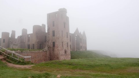 Lady walker goes up steps to Slains Castle in the mist