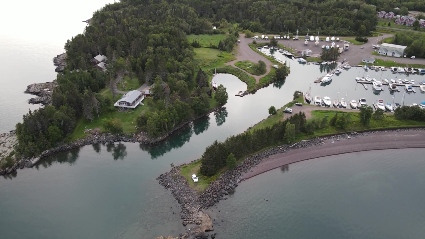 Aerial flyover of boat dock on Lake Superior. Beautifully still water showing reflections. Near Duluth, MN. Outdoors, summer.