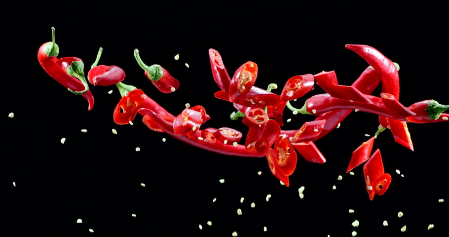 Red chili peppers slowly fly up and fall on a black background. Blackmagic Ursa Pro G2, 300 fps.