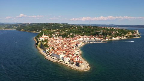 Aerial drone footage of the Piran medieval old town in istria region of Slovenia by the Adriatic sea on sunny summer day. Shot with a forward motion
