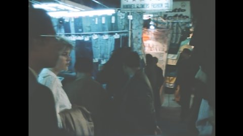 HONG KONG, CHINA - CIRCA 1987: Vintage nightlife of Hong Kong Central with street lights of the Chinese market with tourist people shopping at night. Historical archival in 1980s.
