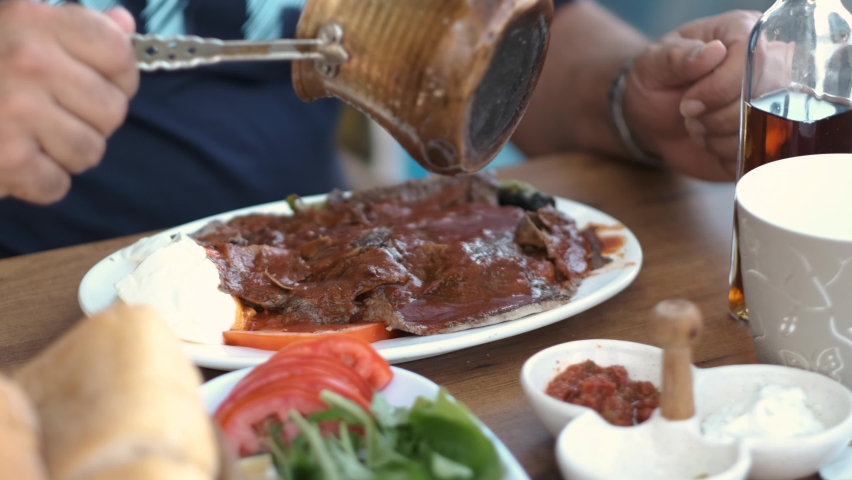 Butter is poured over the served iskender kebab.