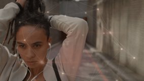 Animation of networks of connections over woman tying dreadlocks and exercising in city. sports, fitness and connections concept digitally generated video.