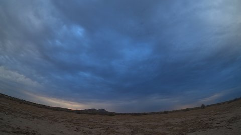 Sunrise is greeted by a brief cloudburst over the drought-stricken landscape of the Mojave Desert - time lapse