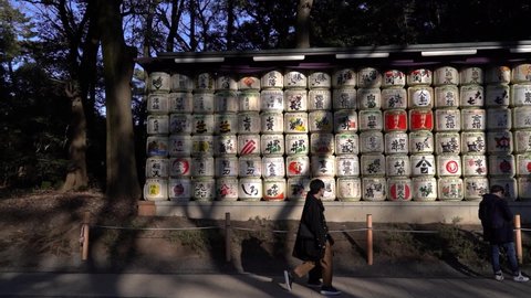 Tokyo , Japan - 02 08 2021: People looking at Sake Barrels at famous Meiji Shrine in Tokyo