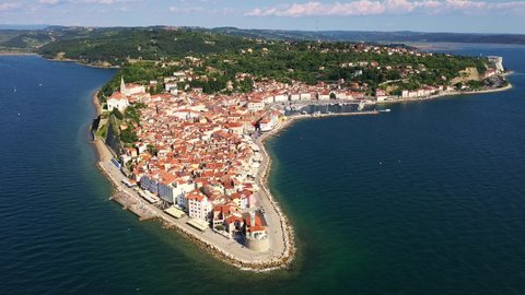 Aerial drone footage of the Piran medieval old town in istria region of Slovenia by the Adriatic sea on sunny summer day. Shot with a downward and tilt up motion