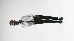 African american man in stylish office clothes dances on white background in studio and smiles, front view, vertical video. Concept of cheerful person - Powered by Shutterstock - Get 15% off with code: PIKWIZARD15