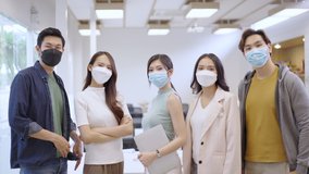 Portrait of Asian creative business team wears face mask. Hipster Creative Startup Young business people in modern office. - Powered by Shutterstock - Get 15% off with code: PIKWIZARD15