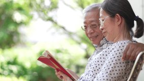 slow motion of senior asian couple laughing while watching social media from tablet at home garden. elderly and technology concept - Powered by Shutterstock - Get 15% off with code: PIKWIZARD15