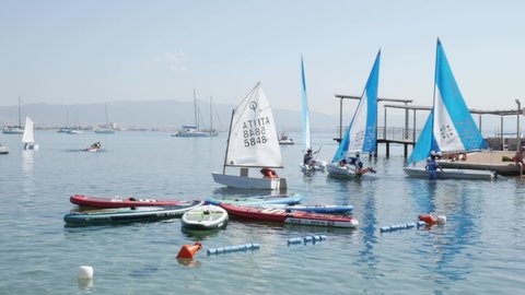 Cagliari, Sardinia, Italy - July 22 2021: group of children takes lessons to learn how to manage small sailing boats