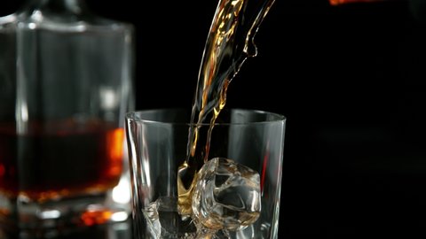 Super slow motion of pouring whiskey or rum with camera motion. Speed ramp effect. Filmed on high speed cinema camera, 1000 fps.