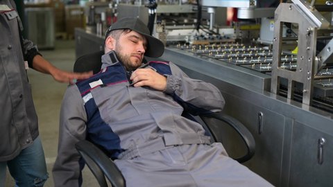A young man, a worker in production fell asleep while working, he was woken up by the production manager. Violation of working conditions and hard work wear down workers