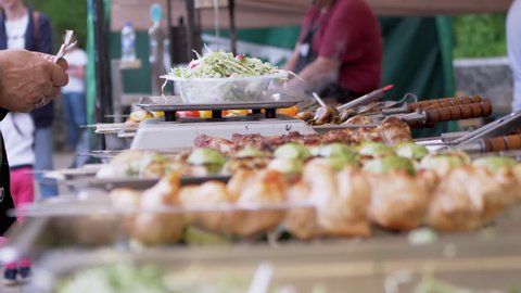 Buyer Pays Cash to Street Food Vendor for Salad in the Lunch Box. Seller weighs instant food on electronic scale. Lots of kebabs, grilled vegetables on the counter. Food truck. Zoom. Slow motion.
