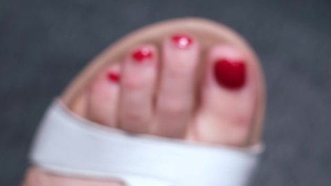 Close up view of caucasian female foot before pedicure. Unkempt nails with ugly, old, red nail polish. Foot spa, hygiene, body care, beauty treatment concept. Dark background, 4k.