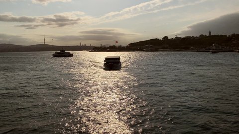 ISTANBUL, TURKEY - SEPTEMBER 21ST 2020: Camera tilts down and follows an Istanbul ferry from the Bosporus at sunrise.