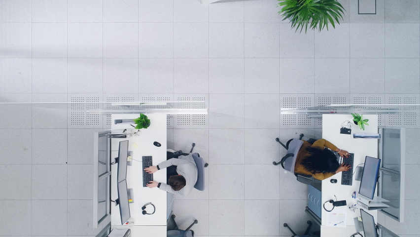 Top Down Footage of a Busy Corporate Office with Tow Rows off Businessmen and Businesswomen Working on Desktop Computers. VFX Animation of Connected Technological Social Network Between Colleagues. | Shutterstock HD Video #1076498990