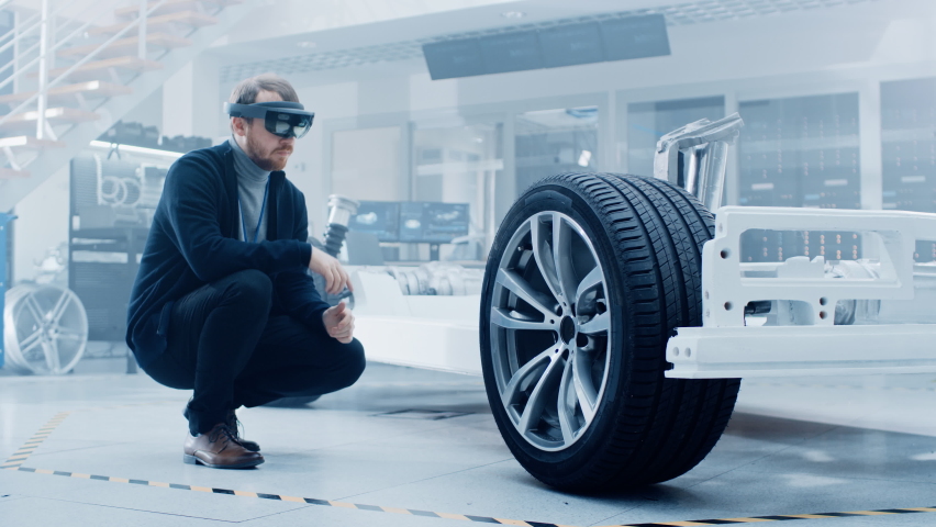 Automotive Engineer Working on Electric Car Chassis Platform, Using Augmented Reality Headset with 3D VFX Software for Development of Regenerative Braking System on a Concept Transport Vehicle. Royalty-Free Stock Footage #1076499092