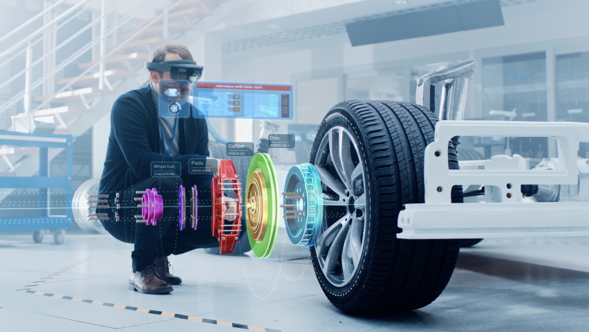 Automotive Engineer Working on Electric Car Chassis Platform, Using Augmented Reality Headset with 3D VFX Software for Development of Regenerative Braking System on a Concept Transport Vehicle. | Shutterstock HD Video #1076499092
