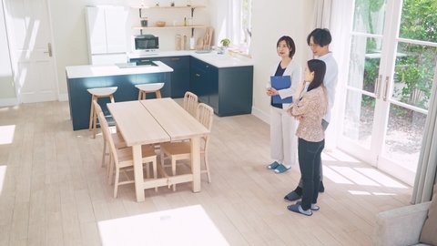 Young businesswoman showing house interior for asian couple.