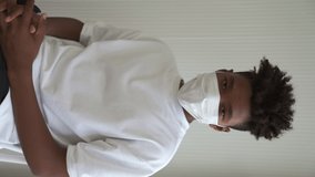 Vertical video of young African man take off face mask removing from face showing concept of the end of quarantine and winning over COVID-19 .