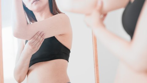 A woman who touches her loose upper arm, diet image