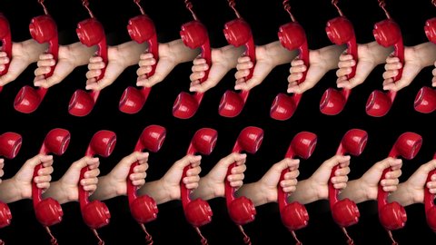Loopable footage of man's hands holding red vintage telephone handsets moving against a black background 