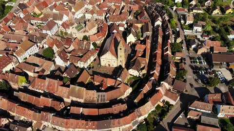 Church with tower in small town surround with old buildings, aerial shot of Eguisheim. Famous village located at Haut-Rhin region of France, part of Alsace Wine Route