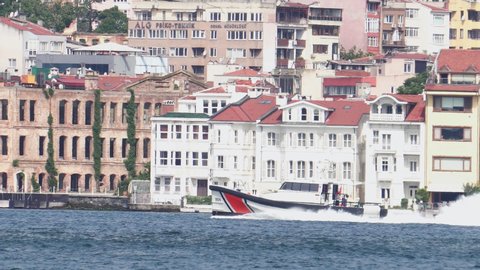 Boat cruise fast on Bosphorus strait passing next to Ortakoy mosque on European part of Istanbul, Turkey