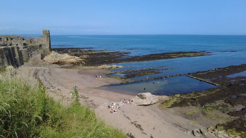 Looking down onto bathers in a tidal pool at Castle Sands in St Andrews, Fife on the East coast of Scotland.