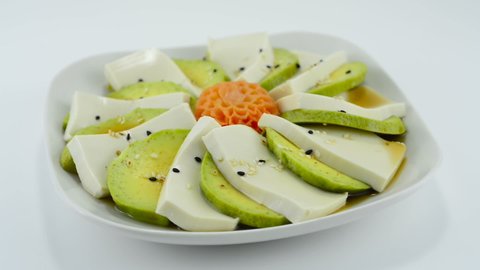 Tofu Avocado Salad with Soy Sauce Japanese Style ontop Sesame decorate carved carrot flower shape sideview