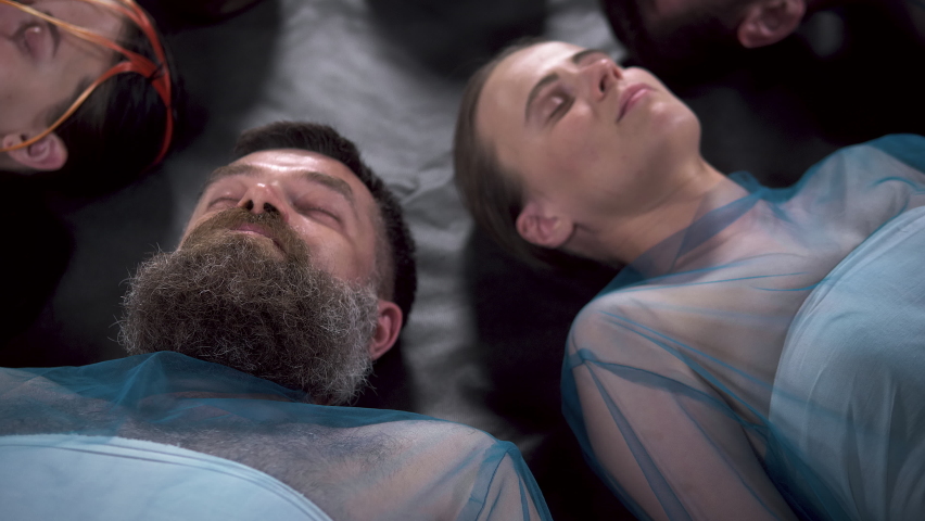 Video of bearded adult man lying on the floor with other people