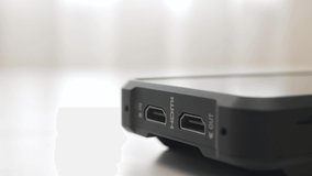 Inserting HDMI cable into the side port of external monitor closeup. HDMI cable is inserted into the socket.