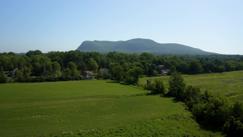 Aerial view of Mount Saint-Hilaire with a field in foreground from drone