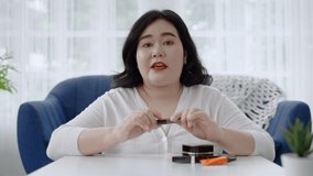 plus size Asian woman bloggers sitting are online to review cosmetic products via social media. concept of health and beauty