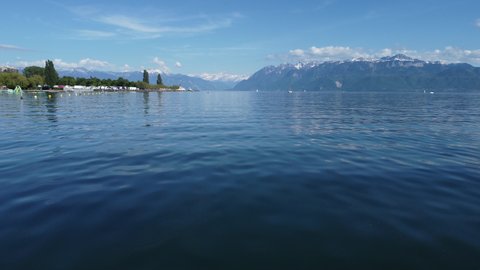 Aerial rise above kayakers on Lake Geneva near Lausanne, Switzerland on a sunny day.