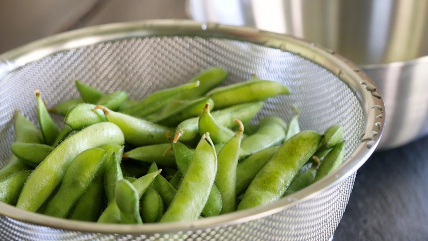 Green soybeans in summer. A video of cutting the edges of edamame with scissors. Royalty-Free Stock Footage #1076559266