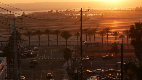 SAN DIEGO, CALIFORNIA USA - 15 JAN 2020: Lindbergh field international airport, airplane on aerodrome in sunset light. Side view of plane on runway. Flight arriving, landing or departure on airfield.
