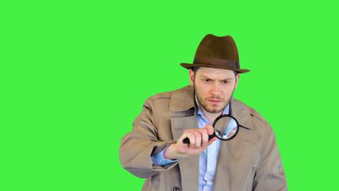 Officer or retro private detective investigating crime looking for evidence with magnifying glass on a Green Screen, Chroma Key.