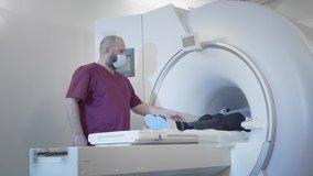 The doctor conducts an MRI or PET scan of a patient in a modern clinic. Girl on the bed inside a 3D scan machine. Magnetic resonance imaging in the study of the human body. The woman is doing CT scan - Powered by Shutterstock - Get 15% off with code: PIKWIZARD15