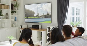 Composite of happy family sitting at home together watching athletics javelin event on tv. sports, competition, entertainment and technology concept digitally generated video.