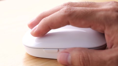 Static shot of a hand moving and clicking a mouse in slow motion