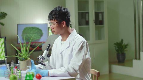 Asian Man Researcher Looking At Aloe Vera. Scientist Observing Genetic Mutation On Plants, Working In Agriculture Laboratory
