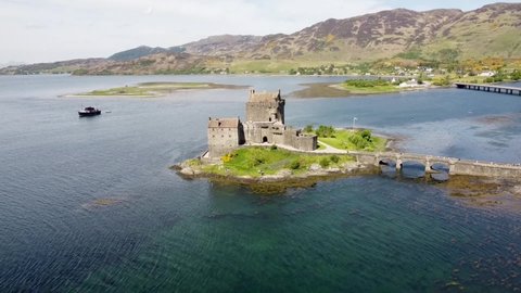 4k drone footage of the ancient Eilean Donan Castle overlooking Loch Duich in the Scottish Highlands, UK