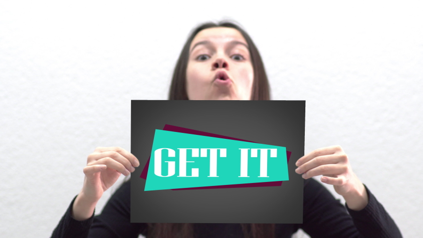 Conceptual message "Get it" on canvas frame label hold by beautiful girl smiling at camera
