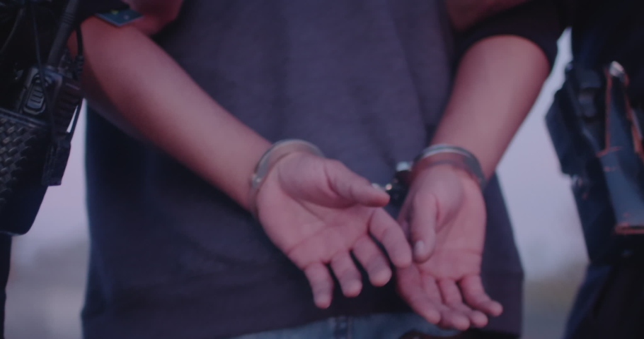 Man Is Put In Hand Cuffs, Arrest By Two Police Officers, Cops, Under Arrest. Hands Behind Back, Walking, Perp Walk Royalty-Free Stock Footage #1076595689