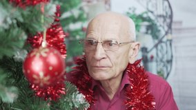 Aged male person in eyeglasses communicating by facetime video call in Christmas eve